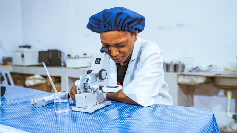 Man looking through microscope at Psaltry International Company Limited